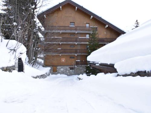 a building covered in snow with snow covered cars at Appartement 3 pièces, piscine, skis aux pieds, centre de Méribel - FR-1-180-136 in Méribel