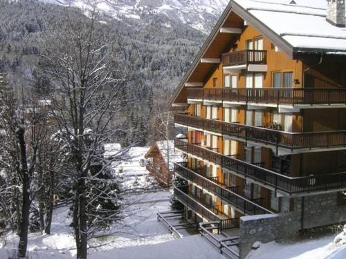 a large building with snow on the ground at Appartement 3 pièces, piscine, skis aux pieds, centre de Méribel - FR-1-180-136 in Méribel