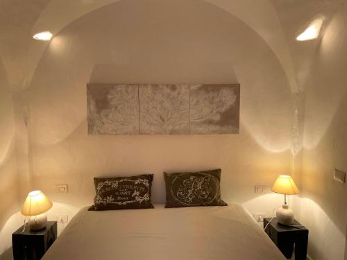 a bedroom with a white bed with two lamps at SAN TEODORO PUNTA EST CURATISSIMO BILOCALe in Capo Coda Cavallo