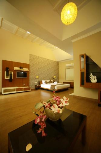 a large room with a bed and a table with flowers at Broad Bean Resort & Spa in Munnar