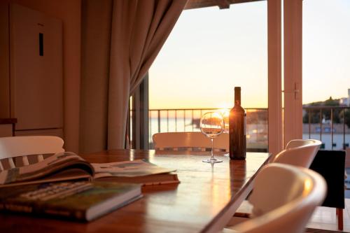 een tafel met een fles wijn en een glas bij D_View in Hvar