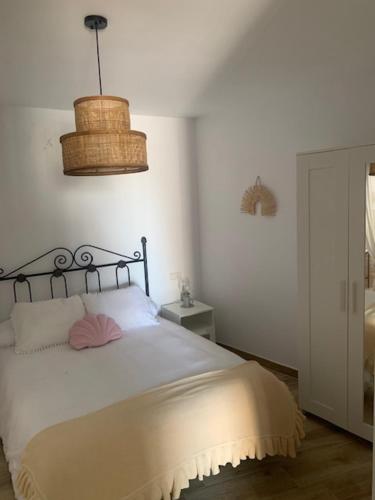 Un dormitorio con una gran cama blanca y una lámpara en Casa El Rinconcito en Mijas