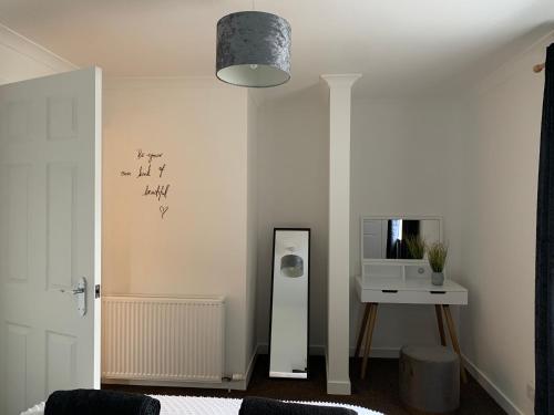 a room with a mirror and a table with a microwave at Dumfries Apartment in Dumfries
