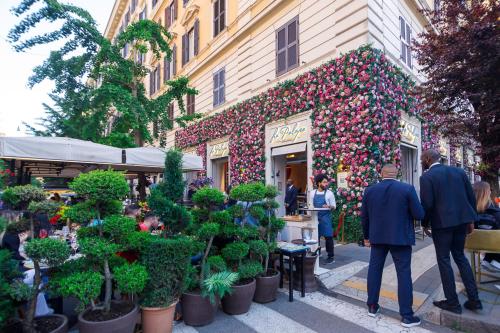 a group of people walking down a street in front of a store at Erreggi Luxury Rooms in Rome