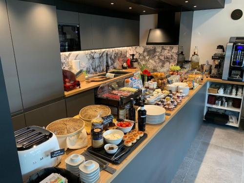 a buffet line with food on it in a kitchen at Visioni Lake View Boutique Rooms & Breakfast - Adults Friendly in Riva del Garda