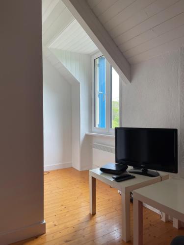 a living room with a tv and a table at Maison de charme entre terre et mer, proche plages in Névez