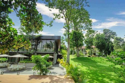 a modern house with a green lawn and trees at Villa Crystals in Colombo