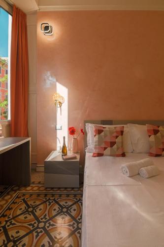 a bedroom with a large white bed and a window at Erreggi Luxury Rooms in Rome