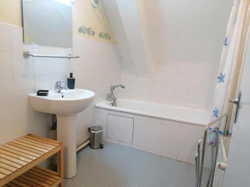 biała łazienka z umywalką i wanną w obiekcie Auberge Chez Gabrielle - Vallée de Lesponne w mieście Beaudéan