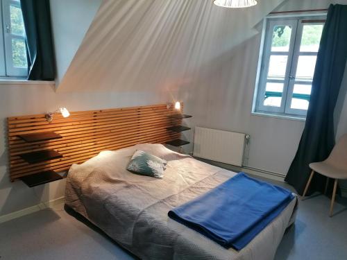 Un dormitorio con una cama con una manta azul. en Auberge Chez Gabrielle - Vallée de Lesponne, en Beaudéan