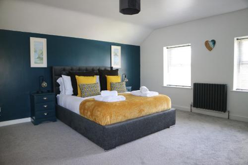 a bedroom with a large bed with yellow and blue walls at 12 Ivy Cottage in St Ives