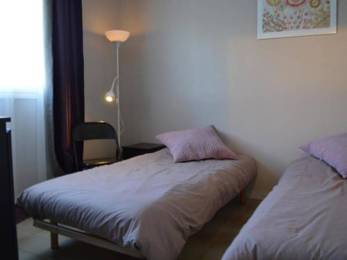 een slaapkamer met een bed, een lamp en een stoel bij Appartement Cavalaire-sur-Mer, 2 pièces, 4 personnes - FR-1-226B-27 in Cavalaire-sur-Mer