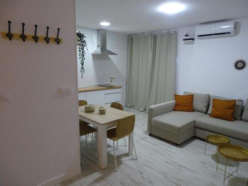 salon z białą kanapą i stołem w obiekcie Casasjerezanas Loft Aitana w mieście Jerez de la Frontera