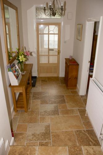 a hallway with a tiled floor and a door at Pear Tree House B&B in Pickering