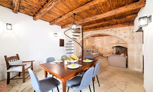 a dining room with a table and chairs and a fireplace at Villa Barozziana Private Heated Pool & Jacuzzi in Rethymno Town