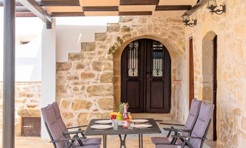 a patio with a table and chairs in front of a door at Villa Barozziana Private Heated Pool & Jacuzzi in Rethymno Town