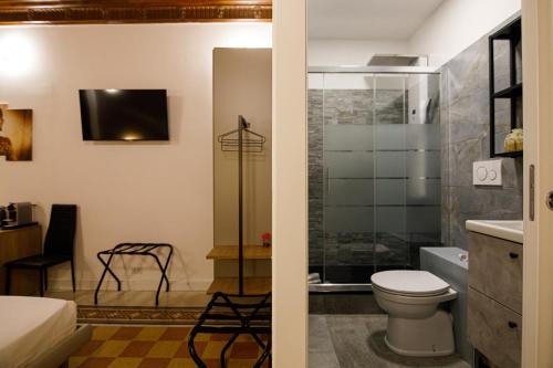 a bathroom with a toilet and a glass shower at Erreggi Luxury Rooms in Rome