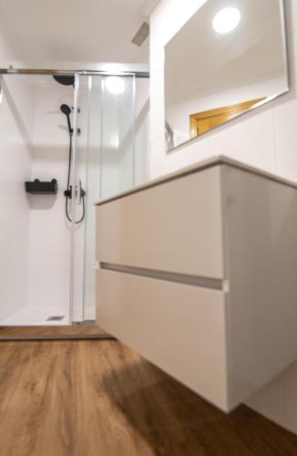 a white bathroom with a sink and a shower at El Balcón de Teruel in Teruel