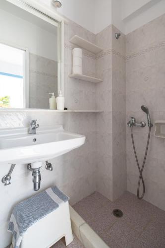 a white bathroom with a sink and a shower at Castello studios in Agia Anna Naxos