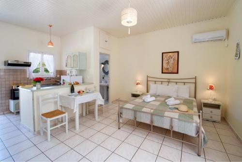 a bedroom with a bed and a small kitchen at LIvadi Studios with Pool in Lákka