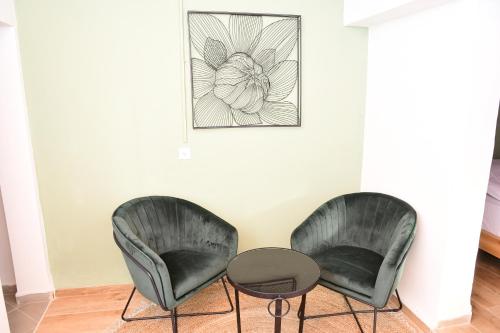 two black chairs and a table in a room at אחוזת המייסדים in Bet Hillel