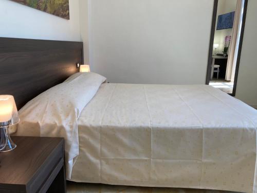 a bedroom with a bed with a white bedspread at Hotel Belvedere in Galleno