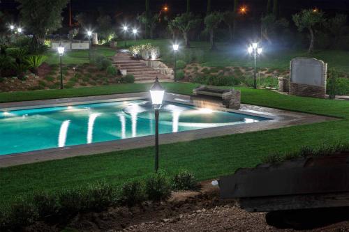 een zwembad 's nachts met een straatlicht bij Tenuta Vento di Mare in Lido Di Fondi