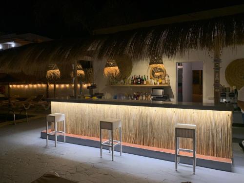 um bar com três bancos em frente a um balcão em Hotel Chevy & Suites em Cala Ratjada