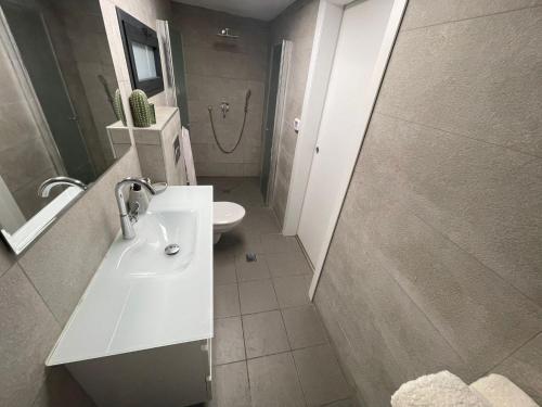 a bathroom with a sink and a toilet and a shower at צדפת המדבר in Giv'ot Bar