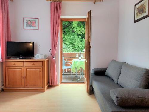 een woonkamer met een bank en een televisie bij Weingut Piewald in Gut am Steg