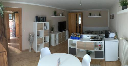ein Wohnzimmer mit einem Tisch und einer Küche in der Unterkunft Pension Alte Schmiede in Greifswald