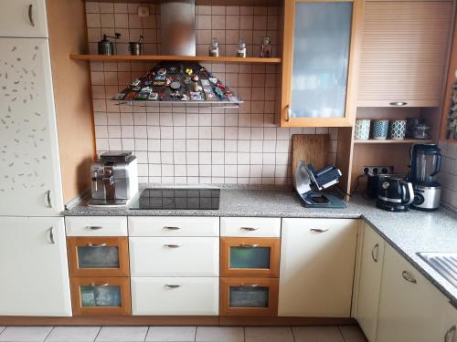 a kitchen with white cabinets and a stove top oven at Feels Like Home Metro Zacisze in Warsaw