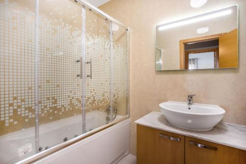 une salle de bain avec un lavabo et une douche en verre dans l'établissement Apartment Beach Waves Home, à Nazaré