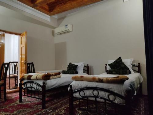 Dos camas sentadas en una habitación con en Hotel Nazira & Azizbek 2, en Bukhara
