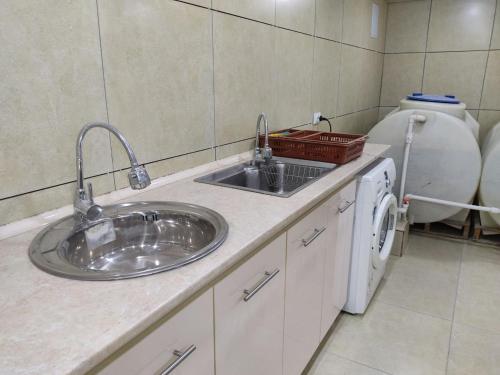 Un baño con lavabo y lavadora. en Hotel Nazira & Azizbek 2, en Bukhara