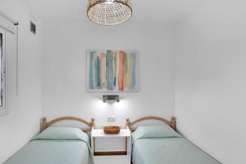 two beds in a room with white walls at Apartamentos Marinera I y II in El Cotillo