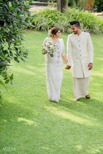 a bride and groom walking down the grass at Villa Crystals in Colombo