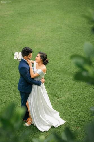 a bride and groom are standing in the grass at Villa Crystals in Colombo