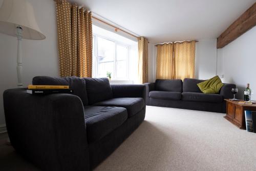 a living room with a blue couch and a window at Character cottage in the heart of Uplyme. in Uplyme