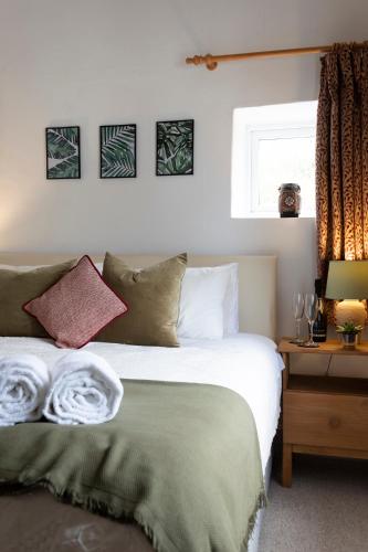 a bedroom with a bed and a table with a window at Character cottage in the heart of Uplyme. in Uplyme