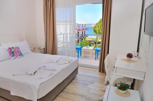 um quarto com uma cama e vista para uma varanda em Allegria Butik Otel em Ildır