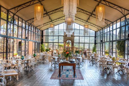 jadalnia ze stołami, krzesłami i oknami w obiekcie Il Falconiere Relais & Spa w mieście Cortona