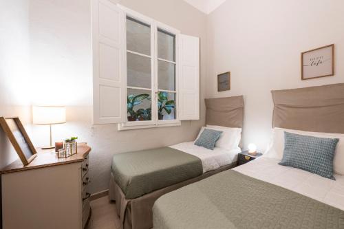 a bedroom with two beds and a window at Apartments Florence - Alfani Terrace in Florence