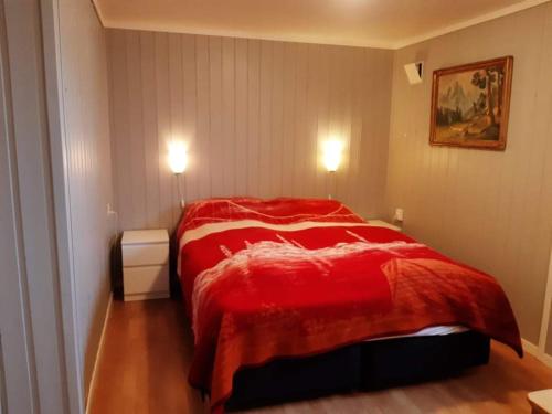 sypialnia z czerwonym łóżkiem w pokoju w obiekcie Fjord side apartment w mieście Røyrvik