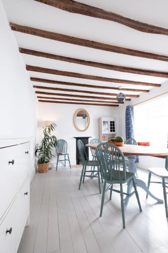 a dining room with a table and chairs at Character cottage in the heart of Uplyme. in Uplyme