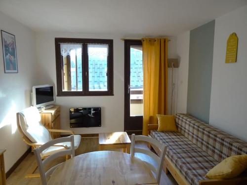 ein Wohnzimmer mit einem Sofa und einem Tisch in der Unterkunft Appartement au cœur du village avec parking privé in Mijoux
