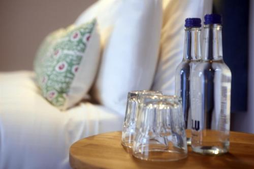 a table with two bottles and glasses on a couch at Embankment Hotel in Bedford