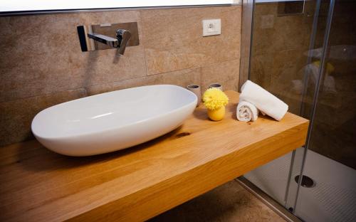 ein weißes Waschbecken auf einer Holztheke im Bad in der Unterkunft Franz Haus Apartments in Meran