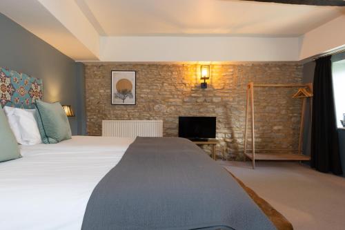 a bedroom with a large bed and a fireplace at Jersey Arms Hotel Bicester in Bicester