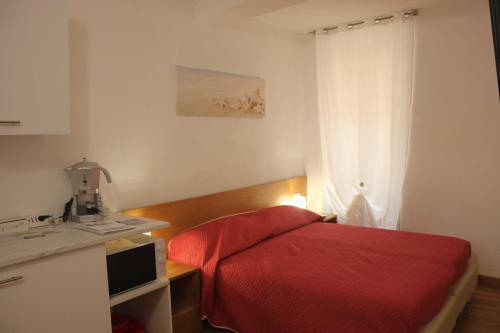 Un dormitorio con una cama roja y una ventana. en Cà dei Pòi - loft Stella Marina, en Riomaggiore